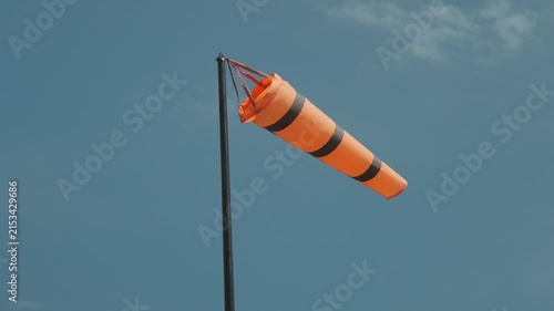 A colorful kite soaring through the air, with a strong wind blowing