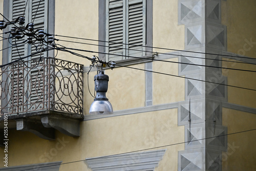 Vintage street lamp and shutters on weathered facade in Bergamo, Italy