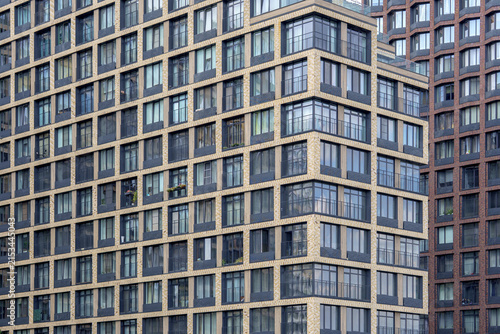 Angular skyscraper facade with glass balconies as a geometric pattern. Residential apartment buildings for real estate backdrop.