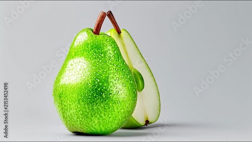 Fresh green pear with water droplets rotates beside its cross-section on a neutral background.