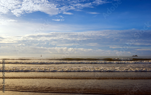 golden morning light on wet sandy beach, sunrise sidelight coastal photography, warm sunlight ocean waves tropical beach