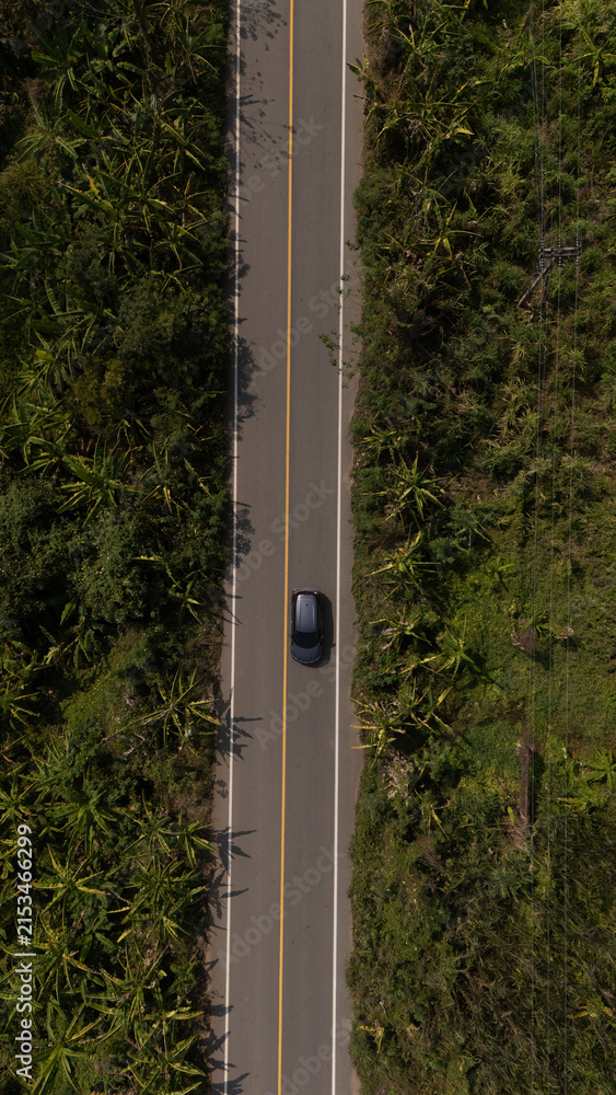 Fototapeta premium Aerial video of a rural road near a mountain with morning mist in Thailand. 