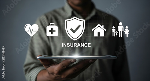 Businessman holding digital tablet with insurance icons for health, home and family protection.