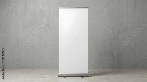 Blank roll up banner stand stands centered in front of a neutral gray concrete wall backdrop.