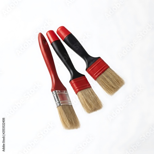 Three paint brushes with red and black handles isolated on white background