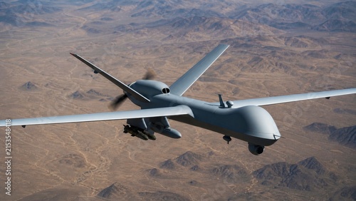 Armed unmanned combat aerial vehicle flying over rugged desert mountains