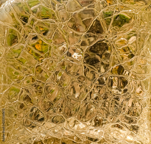 фотографія Square close-up of golden textured glass with irregular reflections, abstract lu