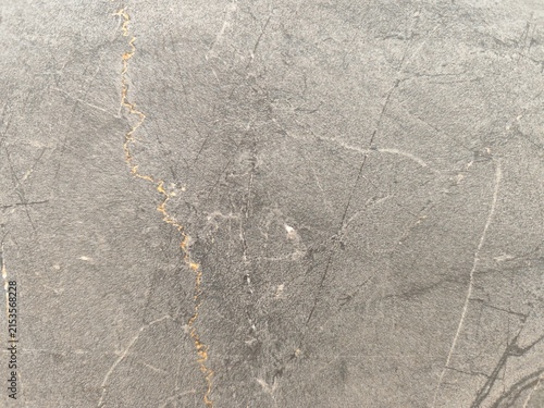 Obraz na płótnie Close up view of dark grey stone texture with distinct orange mineral vein and f