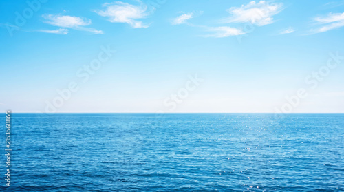 Panoramic view of calm blue ocean horizon with clear sky and light clouds