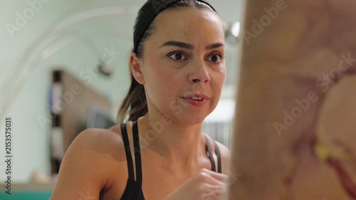 Mexican woman watching an online workout class on her laptop while training at home during the day