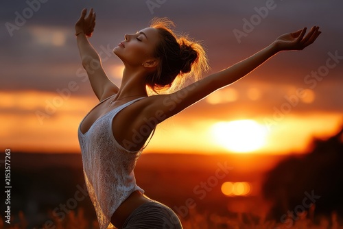 Woman with arms outstretched at sunset