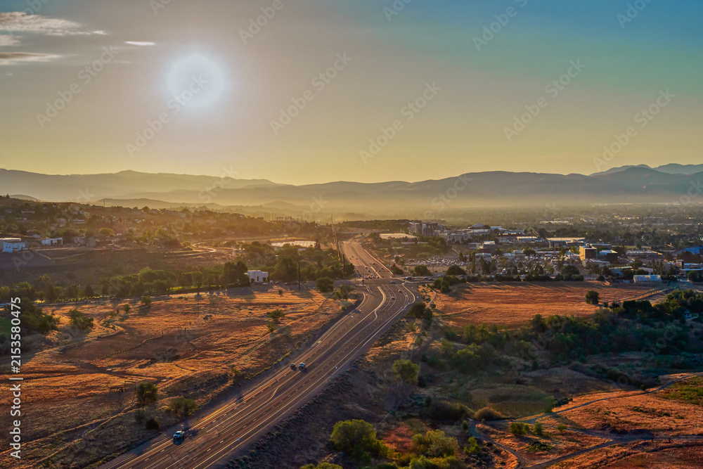 Fototapeta premium Aerial view of a road winding through Pleasant Valley near Washoe Lake along Highway 395 near Reno and Carson City Nevada at Sunrise during summertime.