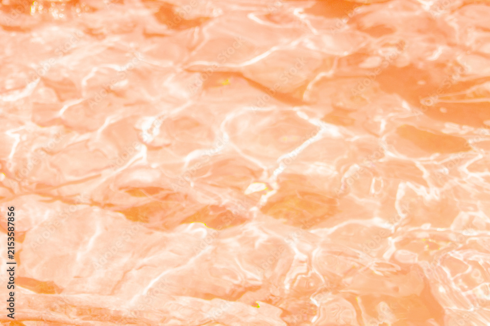 Fototapeta premium Full frame close up view of bright orange water ripples with golden sunlight reflections and caustics pattern background surface concept of pool ocean liquid photo