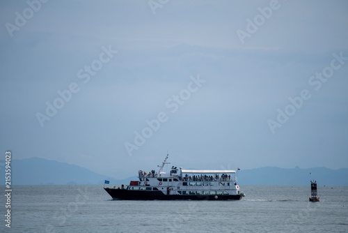 Tourist cruise boat sailing on open sea water with distant mountains