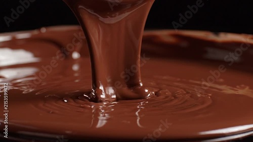 Thick molten chocolate pouring in slow motion with glossy texture and rich brown color