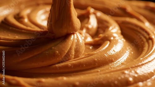 Close-up of creamy peanut butter swirling in a smooth, glossy texture with rich brown color