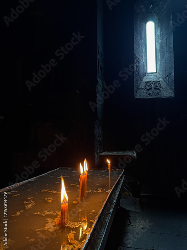 Fotografie Burning candles in a church against a dark background, warm candlelight and spir