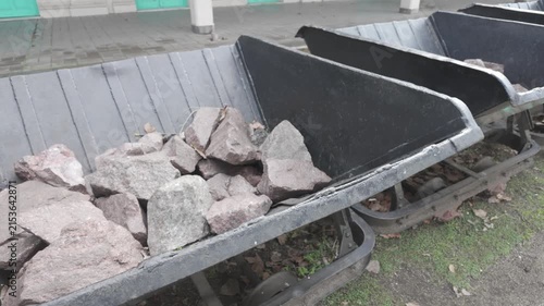 Close-up of metal tipping carts loaded with ballast stone at historic La Plata El Provincial station, Argentina. D-Log M, 10-bit color, flat log profile.