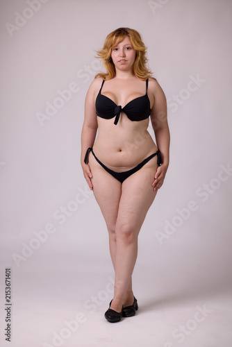 Fototapeta kuchenna Confident curvy woman posing in black bikini