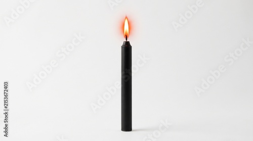 Burning black candle with bright flame on a clean white background