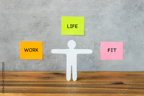 Work life balance and healthy lifestyle concept with white figure and colorful sticky notes spelling work, life and fit. Professional well-being and time management.