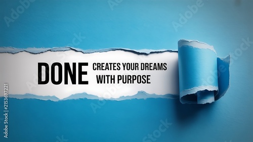 A blue torn paper background revealing the text done creates your dreams with purpose