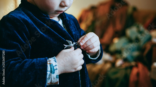 Close Up of Child Buttoning Navy Coat Independently, Kid Getting Dressed with Focus on Hands and Costume Details Indoors