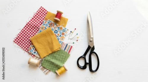 Sewing supplies including fabric scraps, spools of thread, and scissors
