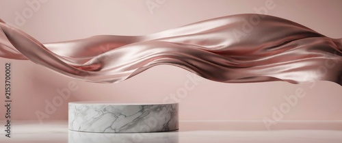 Marble pedestal with flowing rose gold silk fabric on a soft pink background