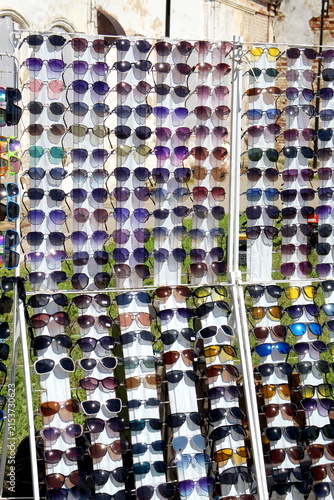 Cuadro en lienzo There is a stand on the street with many different sunglasses.