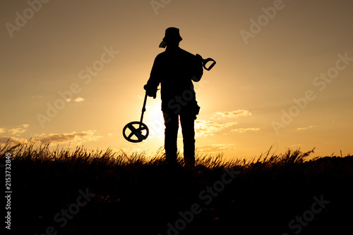 Sunlit Treasure Hunter with Shovel and Metal Detector Facing the Camera