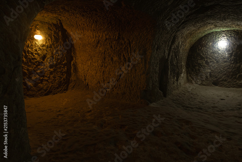 Canvastavla Rock-carved chamber and passageways inside an ancient underground city in Cappadocia, Turkey, illuminated by warm interior lights