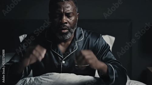 Middle Aged Man Experiencing Headaches And Stress In Bed At Night