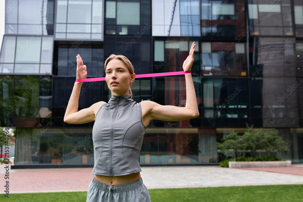 Fototapeta premium Urban workout session as a young woman exercises in a vibrant city setting