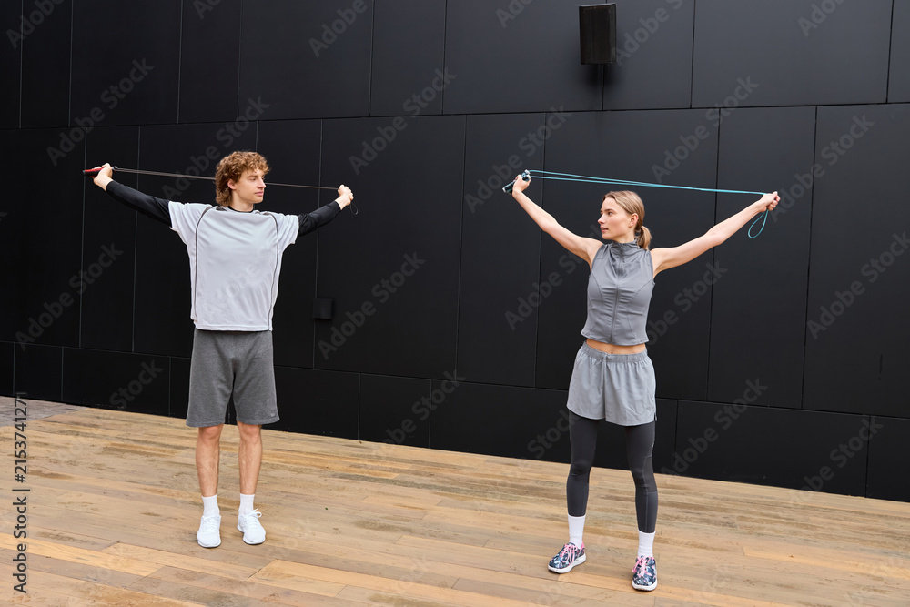 Fototapeta premium Young couple enjoys morning workout outdoors near modern building