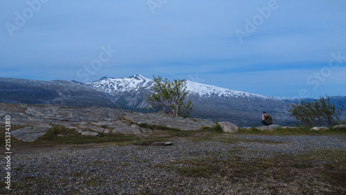 Obraz na plátne Man sitting thoughtfully alone on a rocky mountain viewpoint