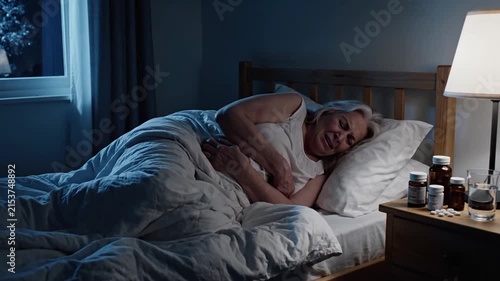 Elderly Woman Suffering In Bed At Night With Medication Nearby 4K Slow Motion