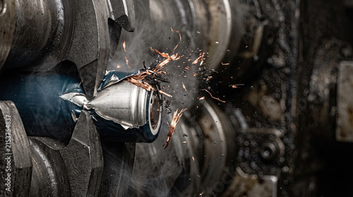 Industrial shredder crushing cylindrical lithium battery cell with sparks flying
