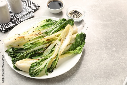 Canvastavla Tasty cooked bok choy cabbages with sesame seeds served on light grey table, closeup