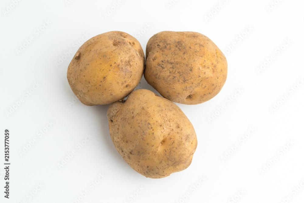 Fototapeta premium Small pile of fresh raw brown baby potatoes isolated on white background