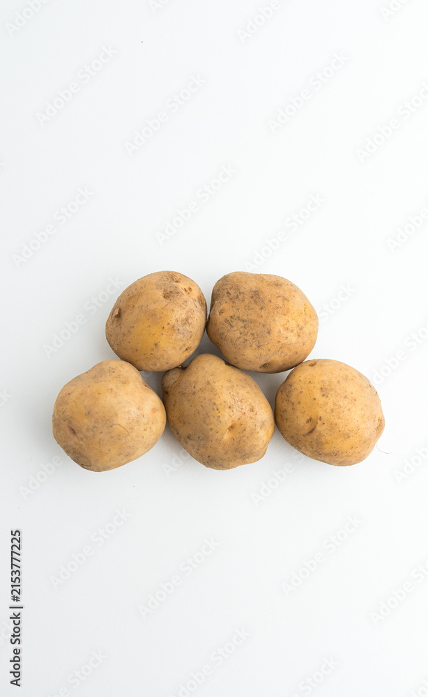 Fototapeta premium Small pile of fresh raw brown baby potatoes isolated on white background