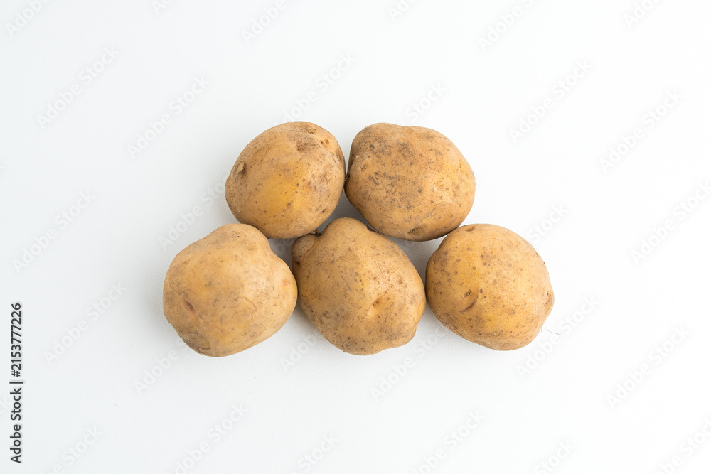 Fototapeta premium Small pile of fresh raw brown baby potatoes isolated on white background