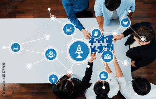 Картината върху платно A top-down view of diverse professionals engaged in collaborative brainstorming with puzzle pieces, highlighting technology and strategy concepts in a modern office environment