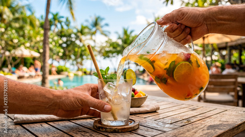Pouring Refreshing Fruit Infused Drink at Tropical Resort Poolside