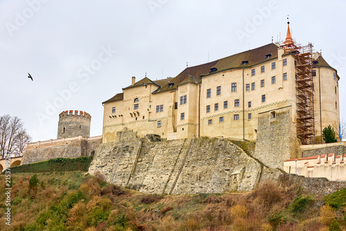 Fotografie Historic european castle with tower and scaffolding on rocky hill