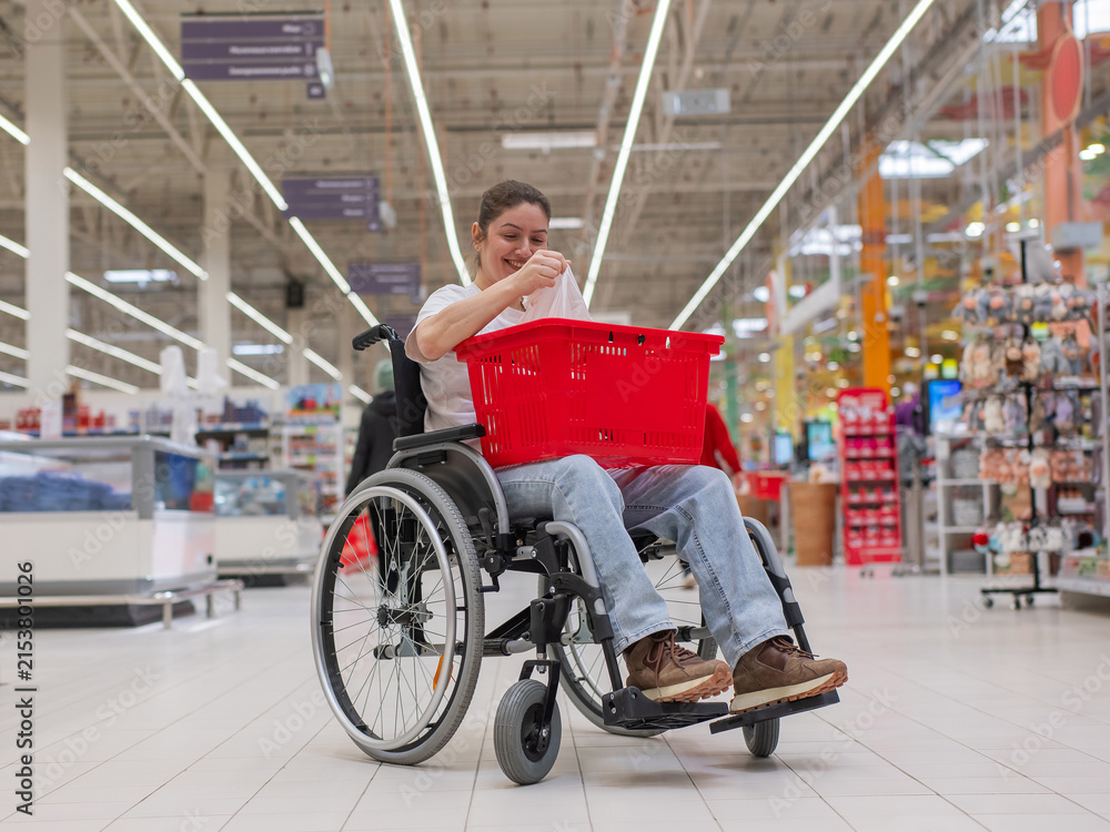 Obraz premium A Caucasian woman in a wheelchair buys fruit at a supermarket.