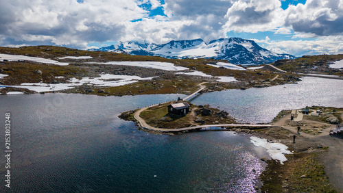 Aerial view of cabin at Sognefjellet, fv 55 scenic route surrounded by distant snow-capped mountains in Lom Municipality, Innlandet, Norway. Sognefjellet mountain pass, Norway
