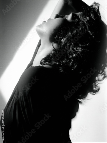 A striking black and white portrait of a woman in a moment of elegant repose.