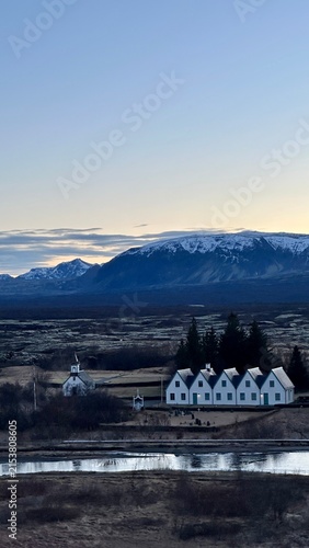 Фотография Icelandic village with snow-capped mountains at sunset