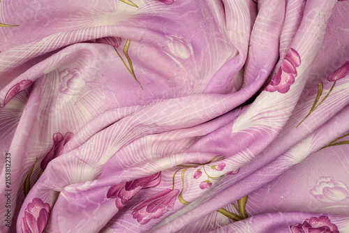 heavily twisted pink fabric with complex folds and a pattern of tulips